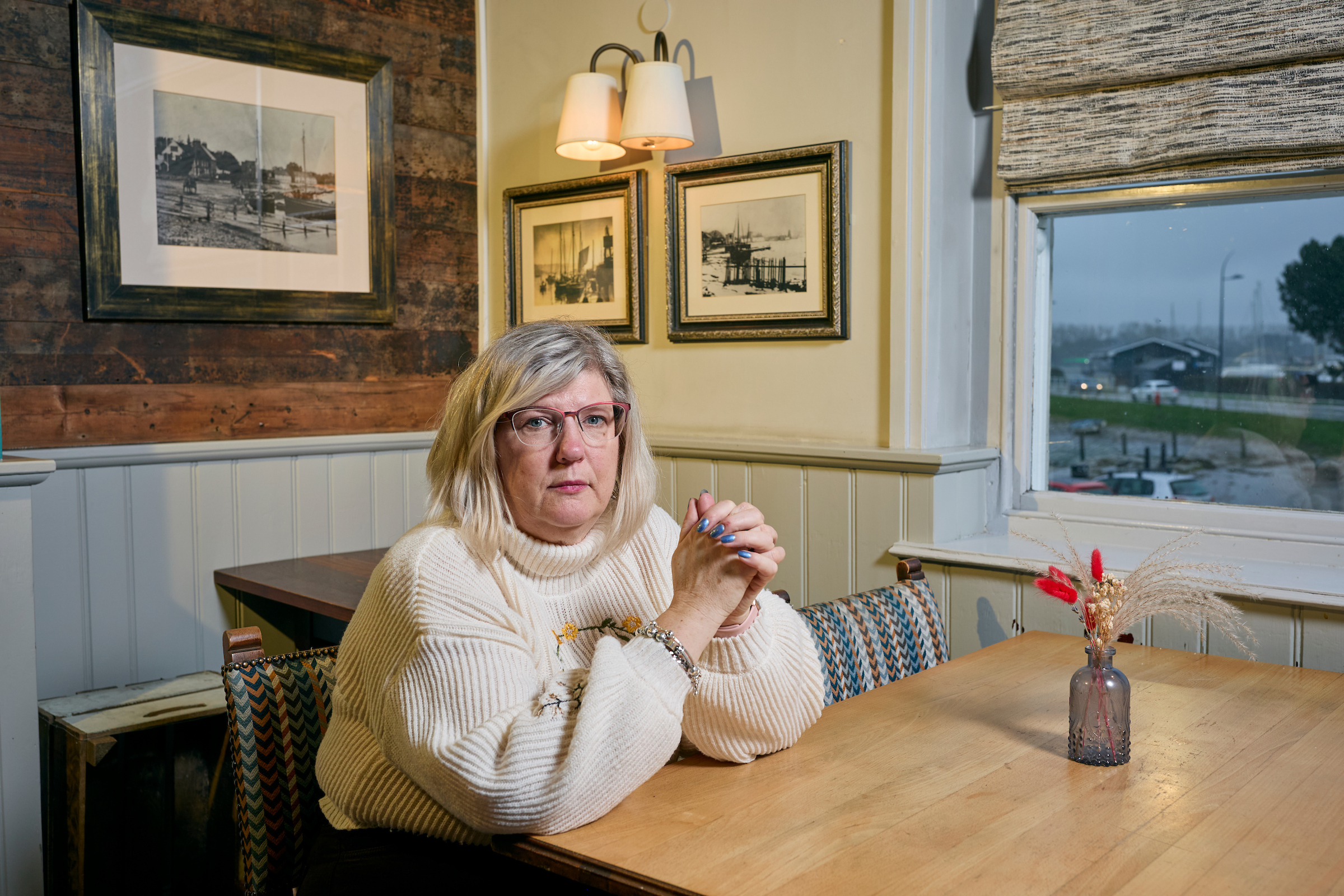 Caroline sits at a table looking at the camera