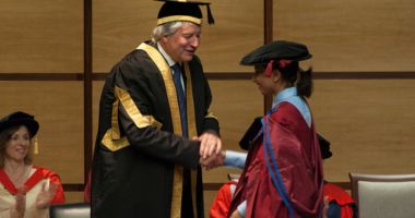 A student receiving a handshake at graduation