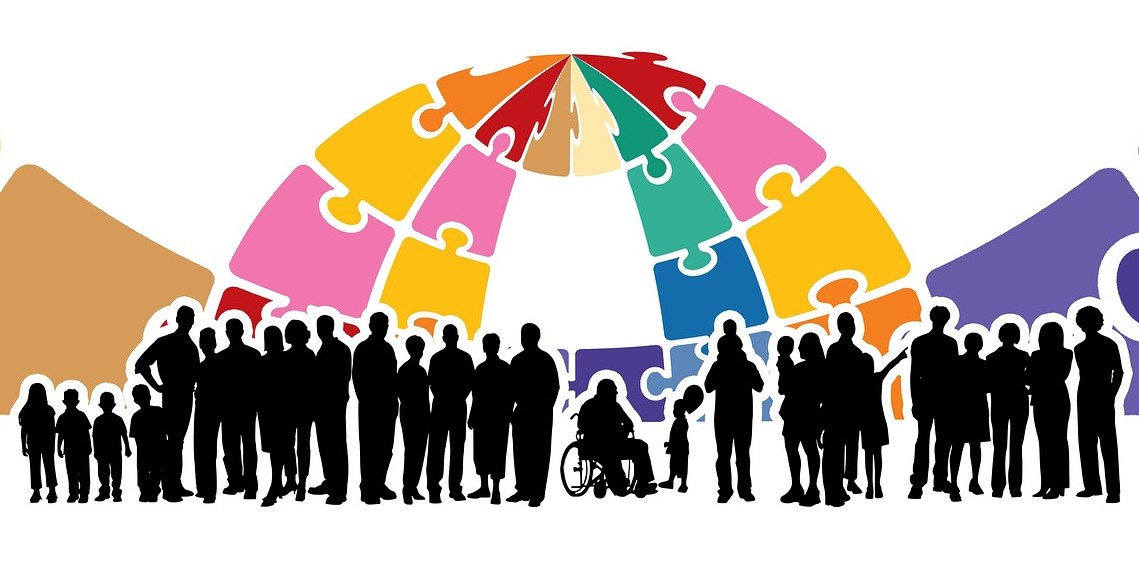 Silhouettes of diverse group of people in front of a dome made of colourful puzzle pieces