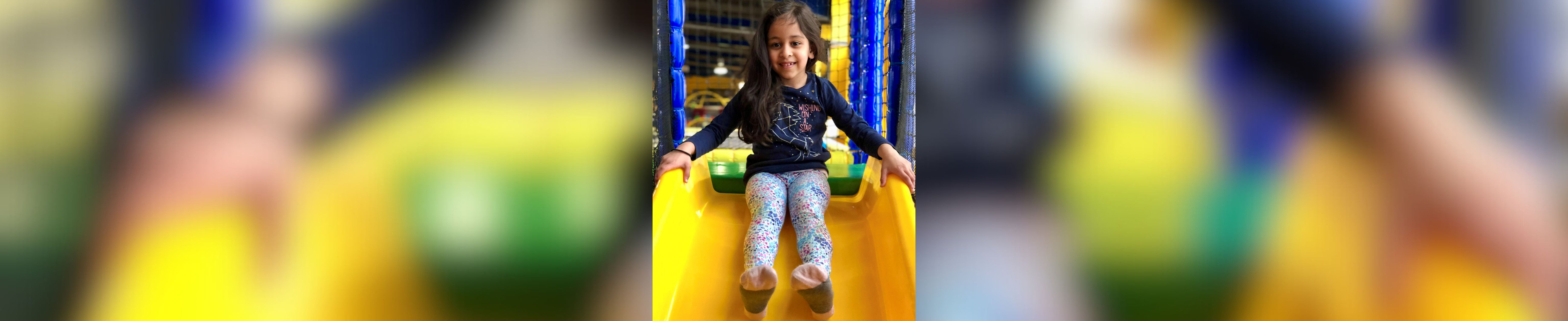 Kaiya on a slide in a softplay