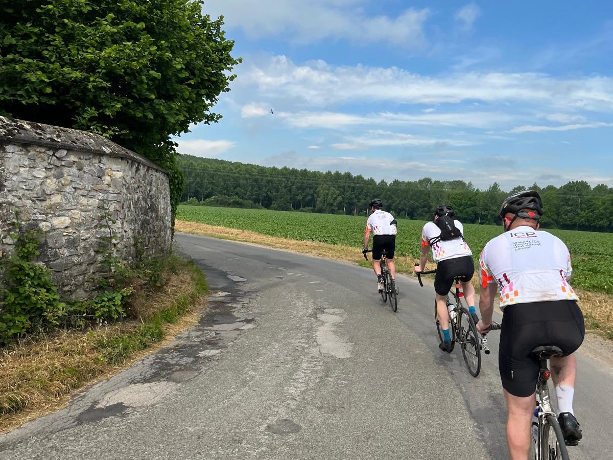 MJS cyclists Three cyclists in ICR jerseys, cycling away from the camera on a rural road