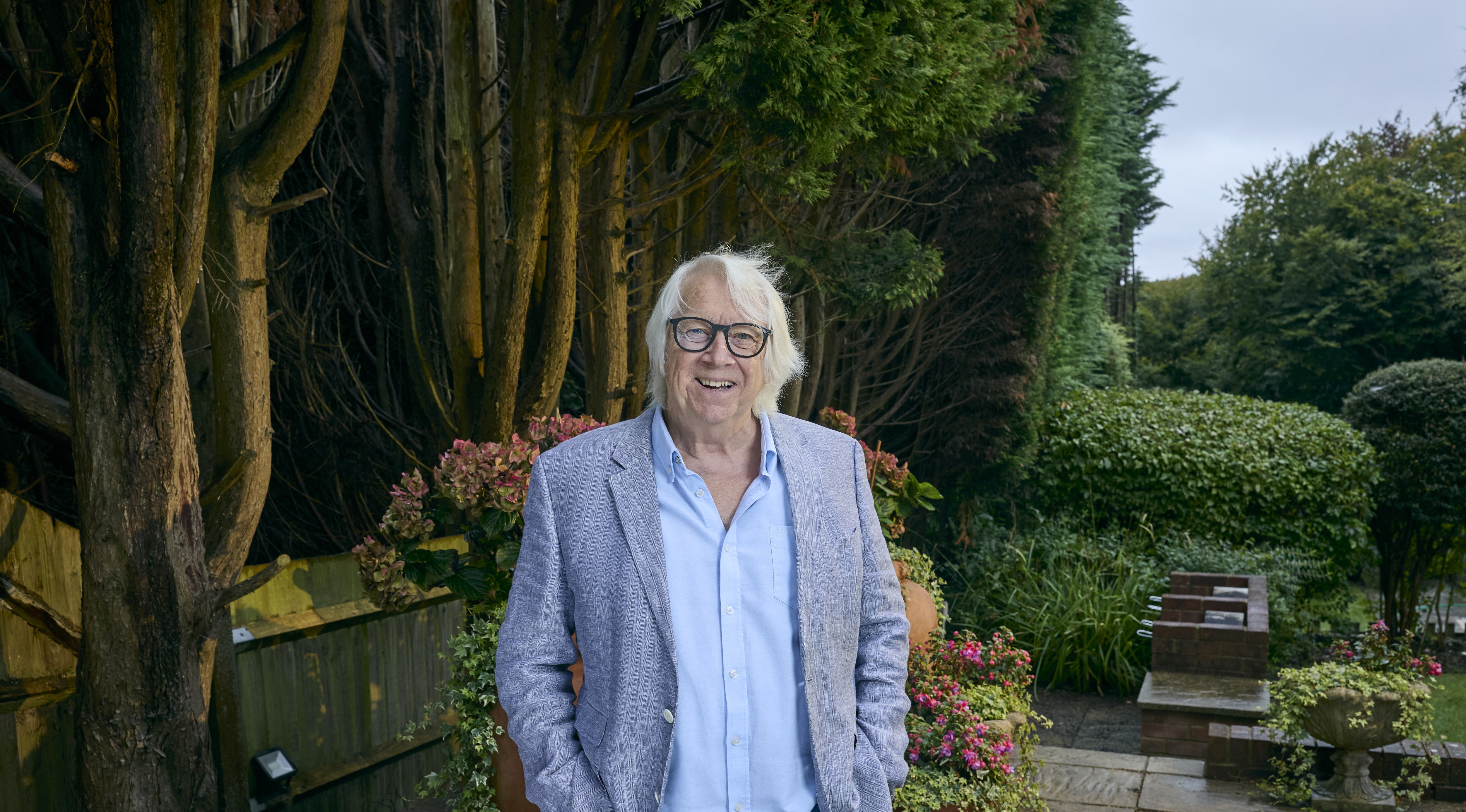 Tony McHale standing in his garden, smiling.