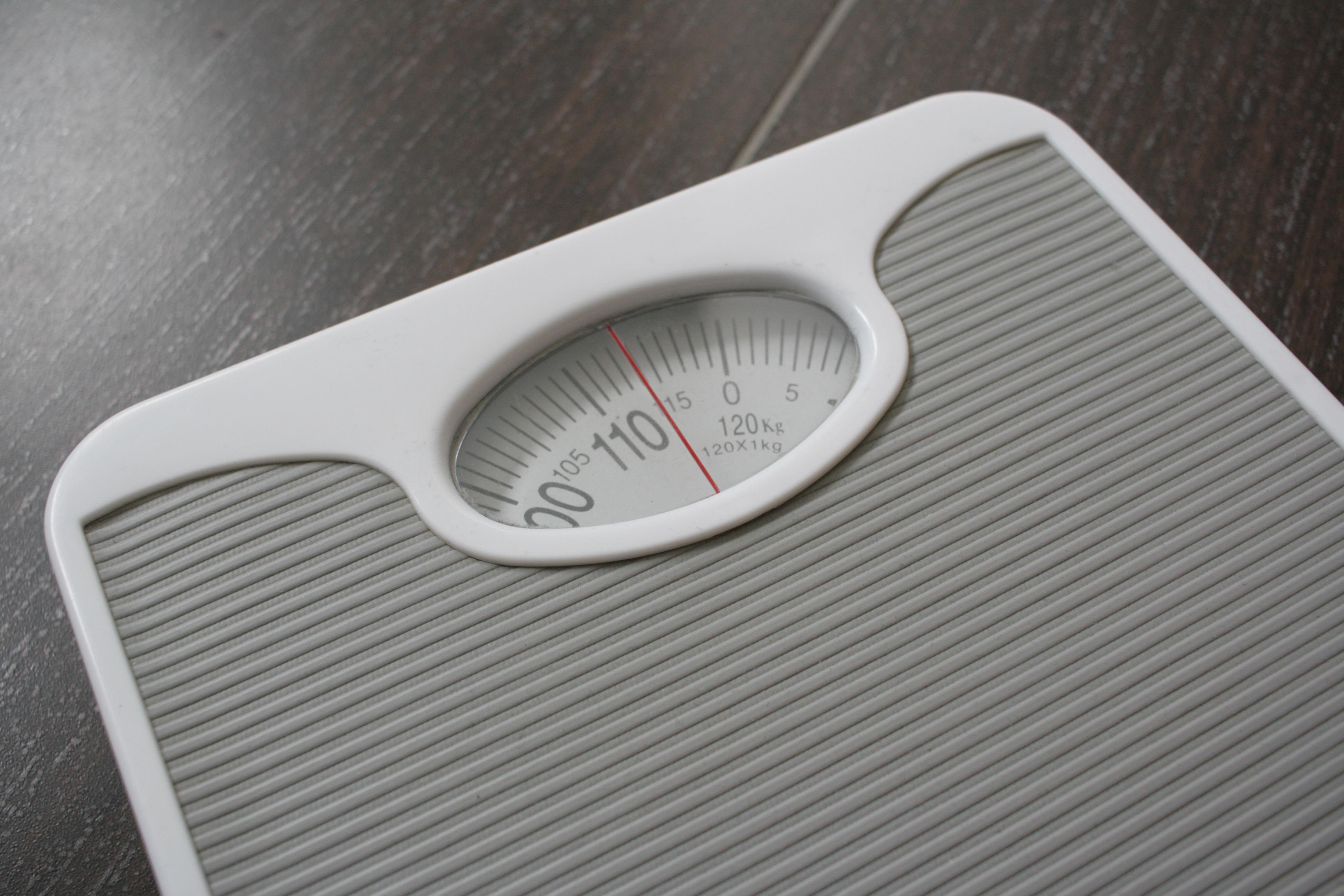 A picture of weighing scales on a grey background