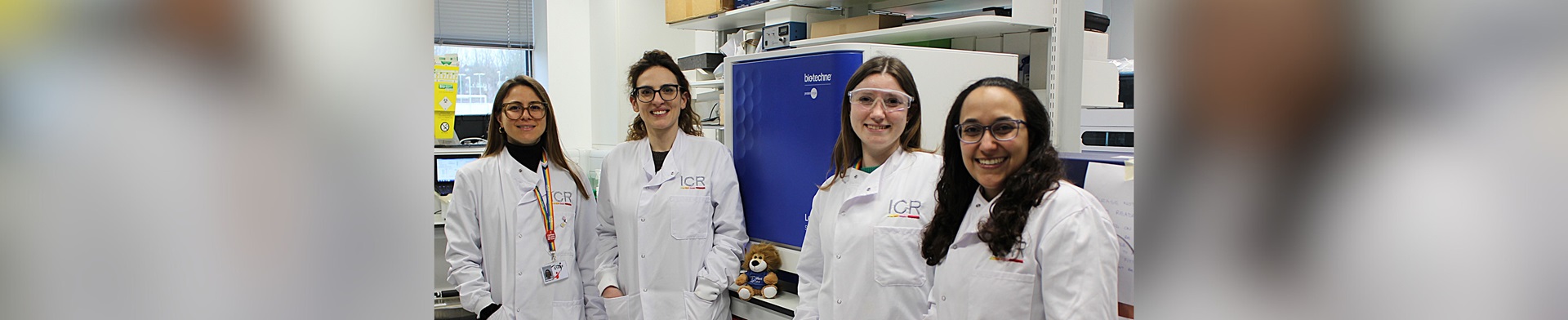Four researchers in lab coats standing next to the Simple Western™ Leo™ System