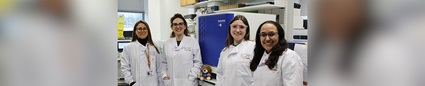 Four researchers in lab coats standing next to the Simple Western™ Leo™ System
