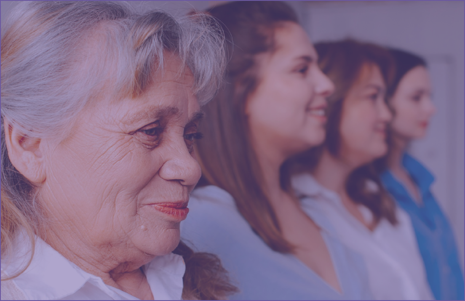 4 women from different generations standing in a row, smiling