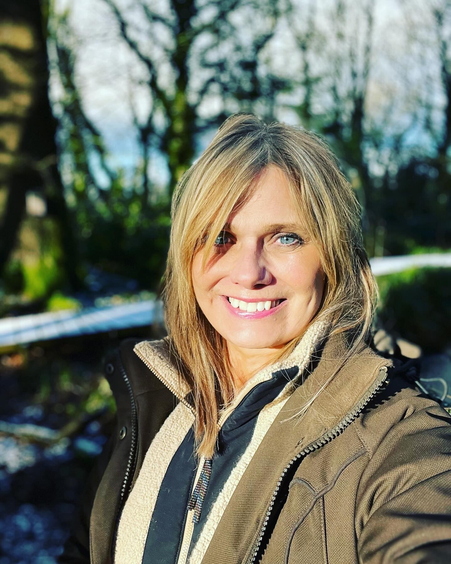 Elen Hughes smiling into the camera, surrounded by nature