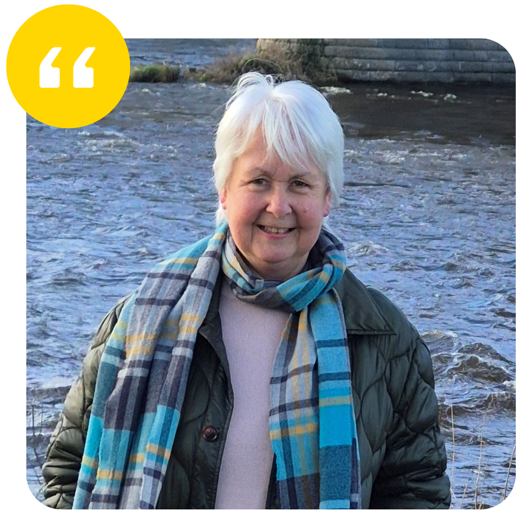 Verity Mutch standing by a river with a quotation mark in a yellow circle