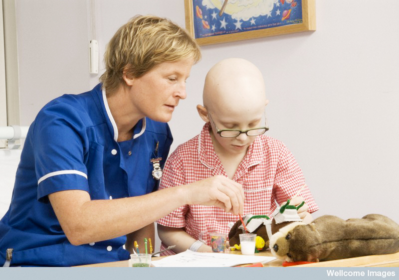Staff nurse playing with a young boy in hospital. He is undergoing treatment for a childhood cancer. Wellcome Images 2007, Creative Commons by-nc-nd 4.0 Staff nurse playing with a young boy in hospital. He is undergoing treatment for a childhood cancer. Wellcome Images 2007, Creative Commons by-nc-nd 4.0
